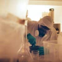 DrugsPersonAndGasMaskInLabForProductionOf